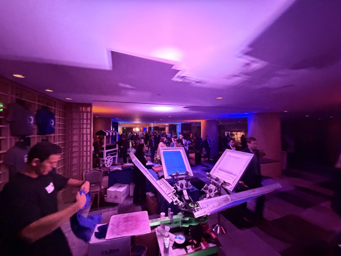 Evening reception under violet lighting with the personalization station in the foreground