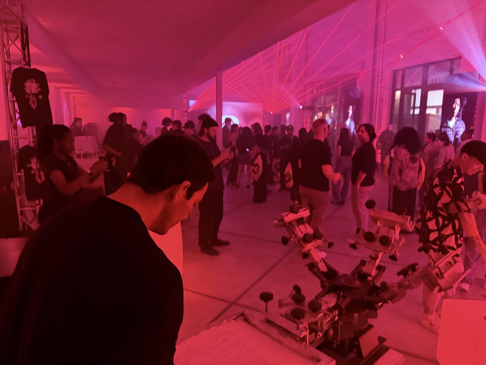 Wide view of a tented evening event with a personalization station drawing a crowd